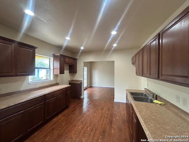 kitchen featuring dark brown cabinetry, dark hardwood / wood-style floors, and sink