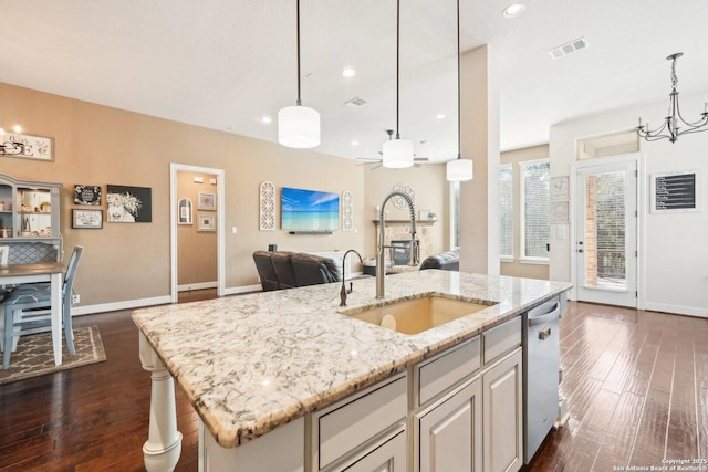 kitchen featuring dark hardwood / wood-style flooring, sink, pendant lighting, a center island with sink, and dishwasher