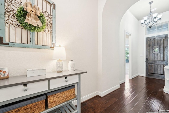 entrance foyer featuring dark hardwood / wood-style flooring and an inviting chandelier