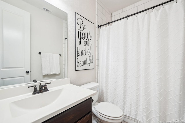 bathroom featuring vanity, a shower with shower curtain, and toilet