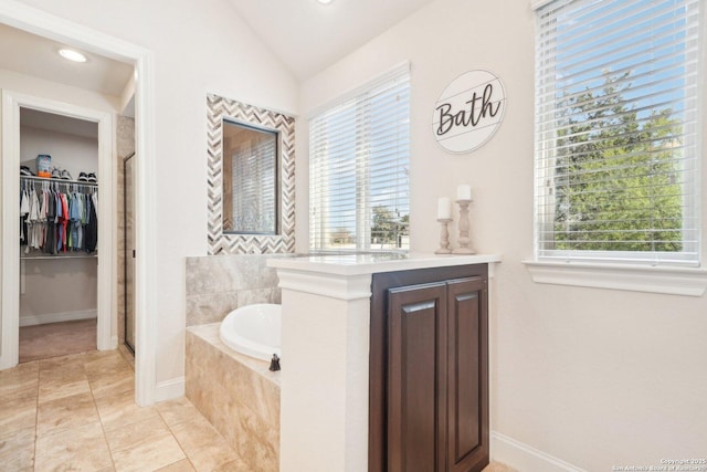 bathroom with tile patterned flooring, vaulted ceiling, and shower with separate bathtub