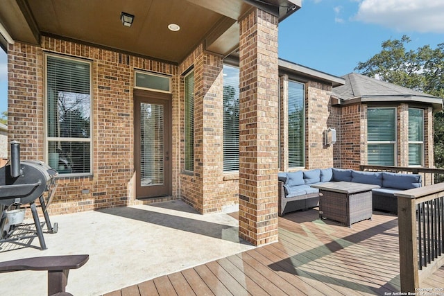 wooden terrace with outdoor lounge area and area for grilling