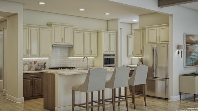 kitchen with a breakfast bar area, backsplash, cream cabinetry, stainless steel appliances, and light hardwood / wood-style flooring