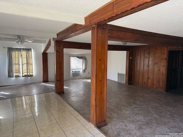 tiled spare room with ceiling fan, beamed ceiling, wood walls, cooling unit, and a textured ceiling