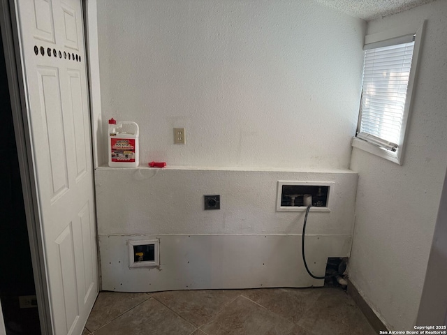 clothes washing area featuring hookup for an electric dryer, washer hookup, and light tile patterned flooring