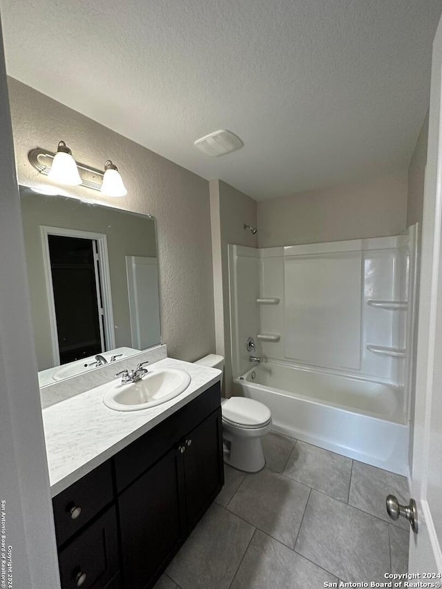 full bathroom with vanity, tile patterned floors, washtub / shower combination, toilet, and a textured ceiling