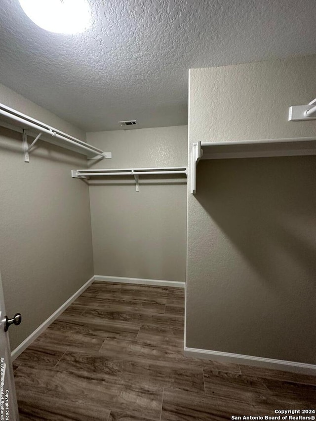 spacious closet with dark wood-type flooring