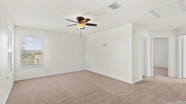 spare room with ceiling fan and light carpet