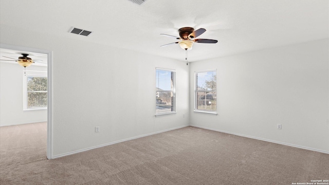 carpeted spare room featuring ceiling fan