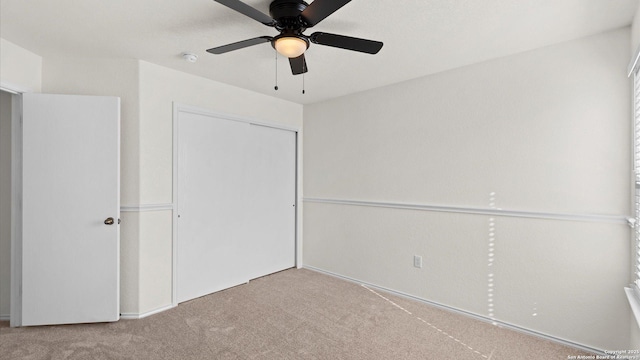 unfurnished bedroom with ceiling fan, a closet, and light colored carpet