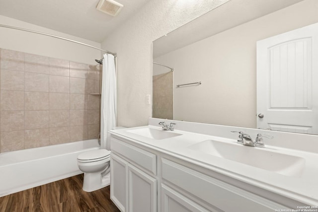 full bathroom featuring shower / bath combination with curtain, vanity, hardwood / wood-style flooring, and toilet