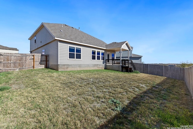 rear view of house featuring a yard and a wooden deck