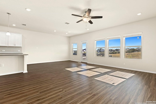 unfurnished living room with ceiling fan and dark wood-type flooring