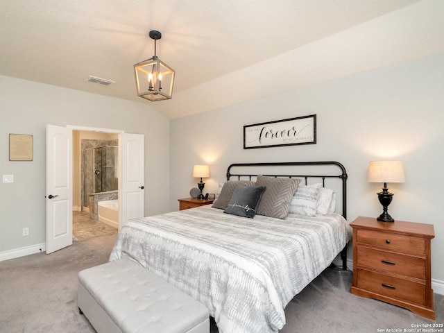 carpeted bedroom featuring ensuite bath, vaulted ceiling, and an inviting chandelier