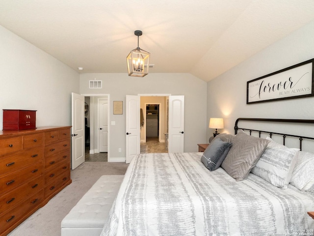 carpeted bedroom featuring an inviting chandelier and lofted ceiling