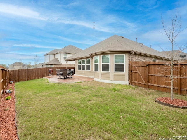 rear view of property featuring a lawn and a patio area