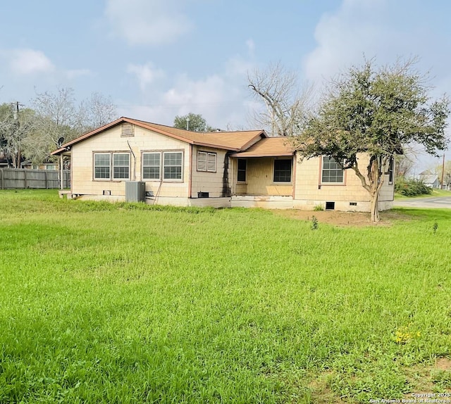 back of property featuring a lawn and cooling unit