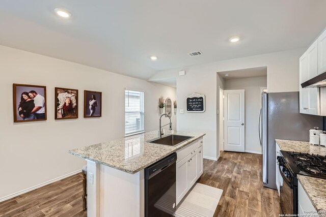 2917 Brogan Crk, New Braunfels, TX 78130 - kitchen with a kitchen island with sink, black appliances, white cabinetry, light stone counters, and wood-type flooring