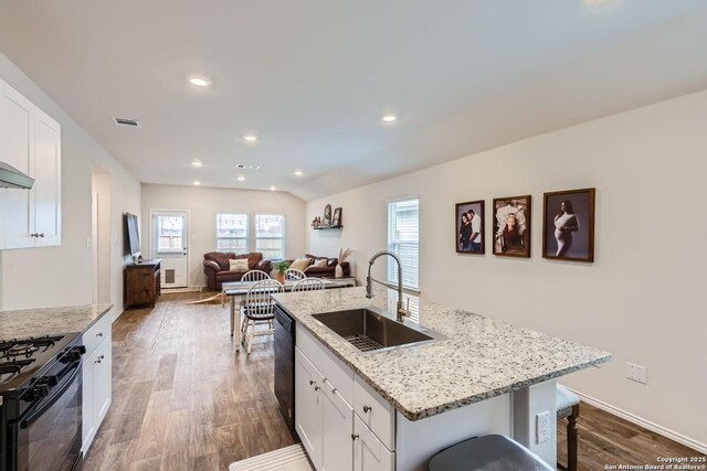 2917 Brogan Crk, New Braunfels, TX 78130 - kitchen with sink, white cabinets, black appliances, and a center island with sink