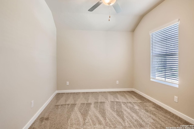 carpeted spare room featuring vaulted ceiling and ceiling fan