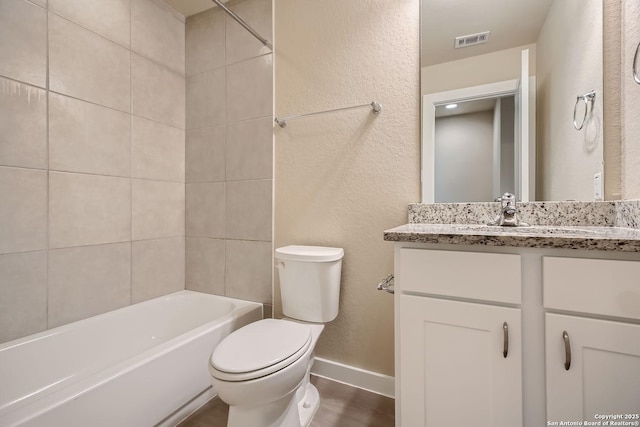 full bathroom with vanity, toilet, and tiled shower / bath