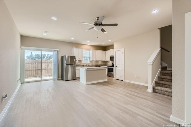 kitchen with ceiling fan, light hardwood / wood-style flooring, white cabinets, and appliances with stainless steel finishes