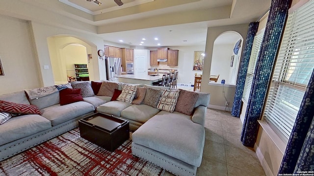 tiled living room featuring a raised ceiling