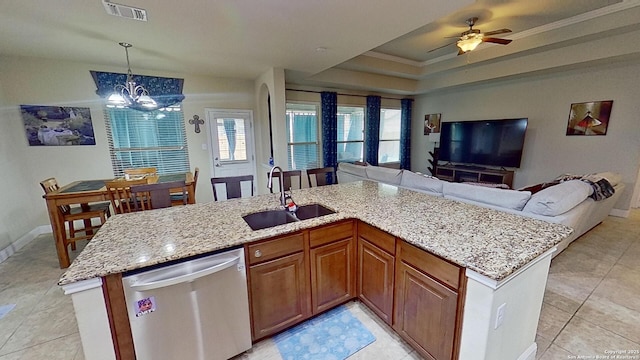 kitchen with sink, a raised ceiling, stainless steel dishwasher, an island with sink, and decorative light fixtures