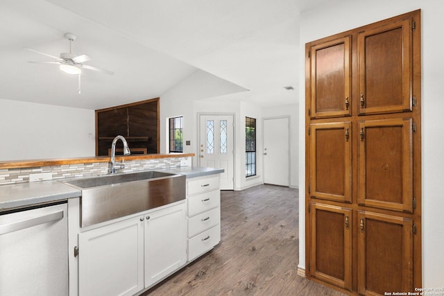 kitchen with backsplash, dishwasher, light wood-type flooring, and sink