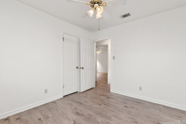 spare room with ceiling fan and light wood-type flooring