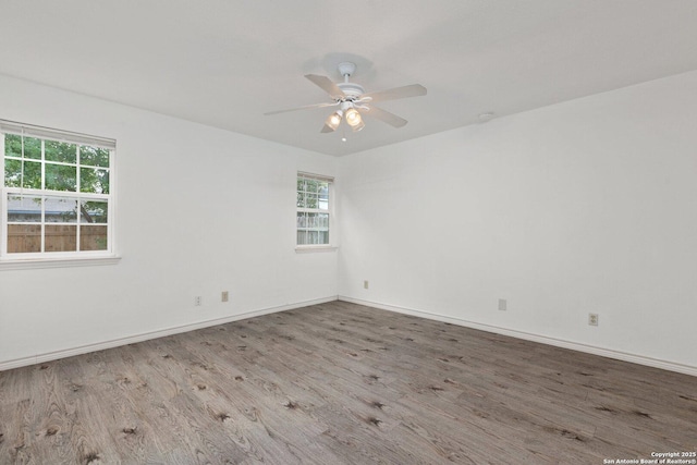 unfurnished room with ceiling fan, a healthy amount of sunlight, and wood-type flooring