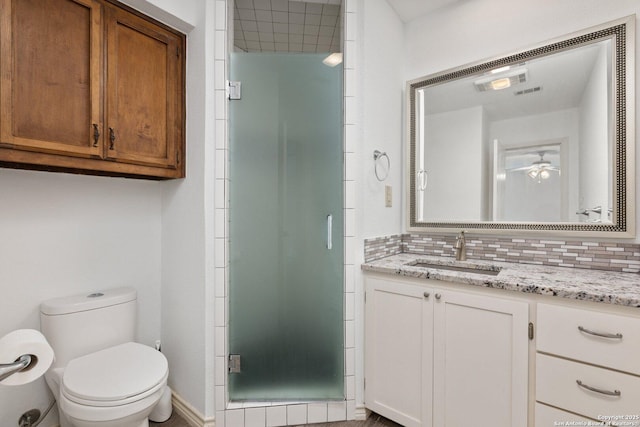 bathroom featuring ceiling fan, walk in shower, backsplash, toilet, and vanity