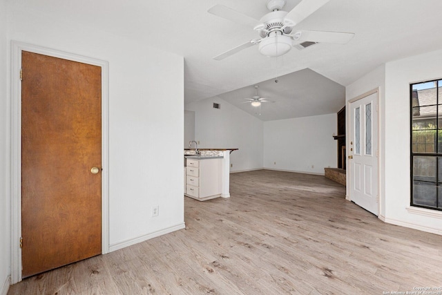 unfurnished living room with ceiling fan, light hardwood / wood-style flooring, and vaulted ceiling