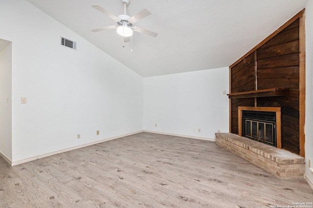 unfurnished living room with light wood-type flooring, a brick fireplace, ceiling fan, and lofted ceiling