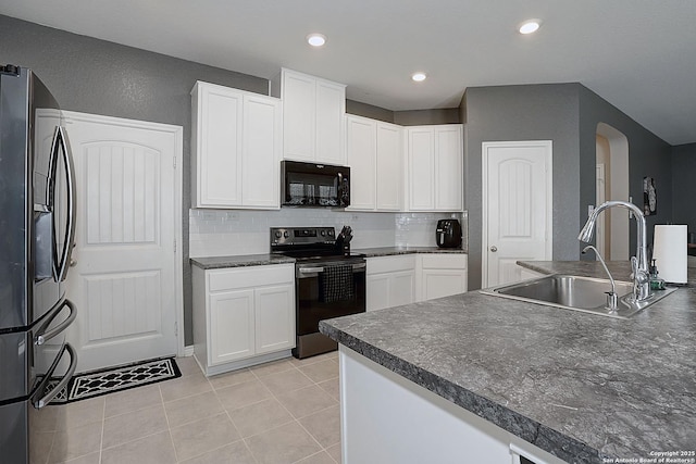 kitchen featuring decorative backsplash, appliances with stainless steel finishes, sink, white cabinets, and light tile patterned flooring