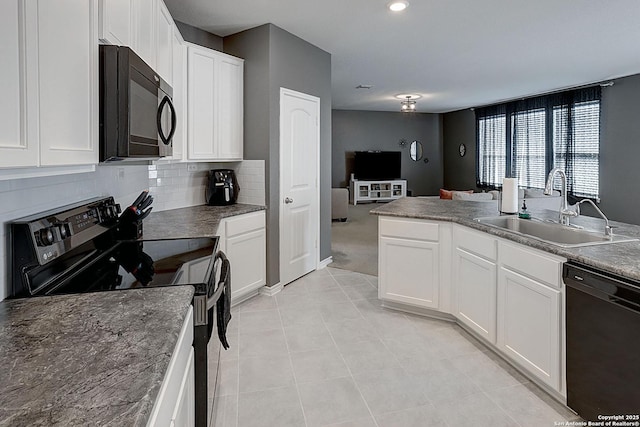 kitchen featuring light carpet, tasteful backsplash, sink, black appliances, and white cabinetry