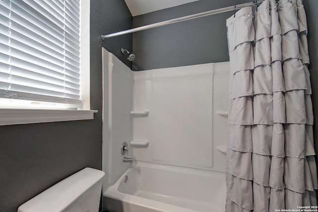 bathroom featuring toilet and shower / tub combo with curtain