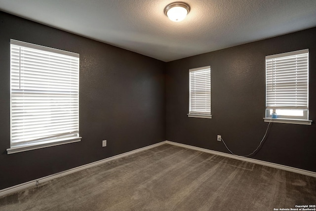 carpeted spare room featuring a textured ceiling