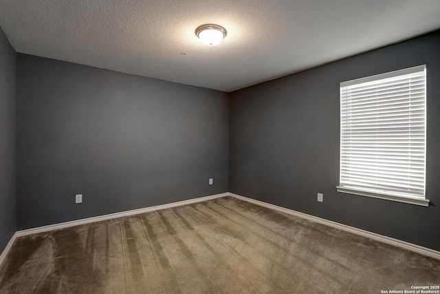 carpeted spare room with a textured ceiling