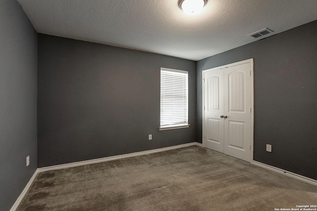 carpeted spare room featuring a textured ceiling