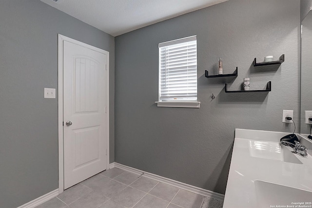 laundry room featuring light tile patterned floors and sink