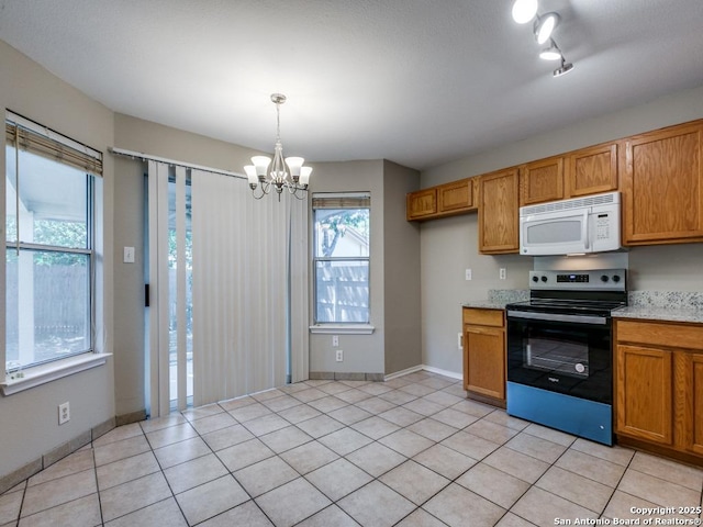 kitchen with a healthy amount of sunlight, light tile patterned floors, a chandelier, stainless steel electric range oven, and hanging light fixtures