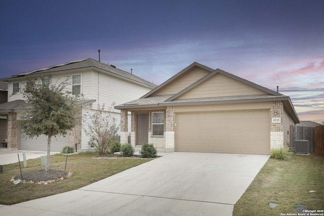 view of front of property featuring central air condition unit, a yard, and a garage