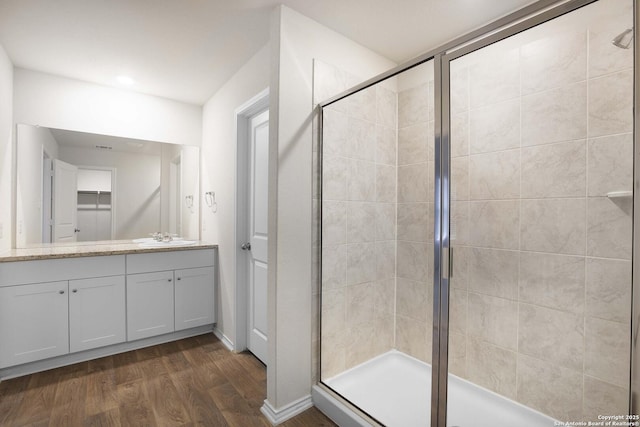 bathroom featuring a shower with shower door, vanity, and hardwood / wood-style flooring