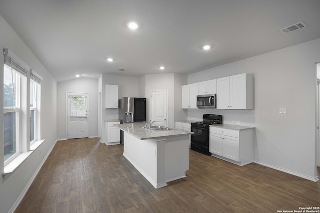 kitchen with white cabinets, dark wood-type flooring, stainless steel appliances, sink, and a center island with sink