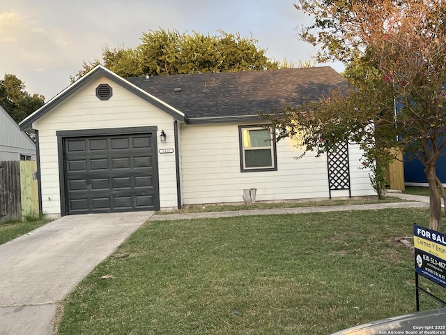 ranch-style house featuring a garage and a front lawn