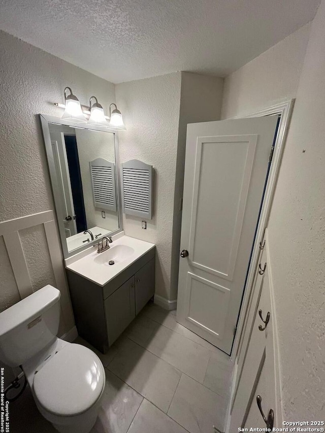 7438 Rimhurst, San Antonio, TX 78250 - bathroom featuring a textured wall, a textured ceiling, vanity, and toilet