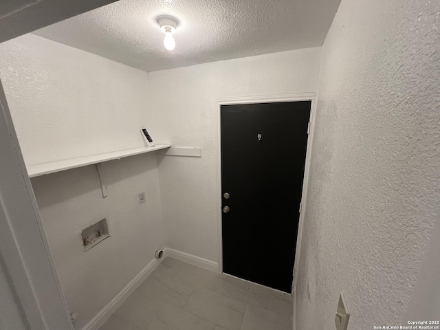 7438 Rimhurst, San Antonio, TX 78250 - washroom featuring a textured ceiling, washer hookup, marble look tile flooring, a textured wall, and baseboards