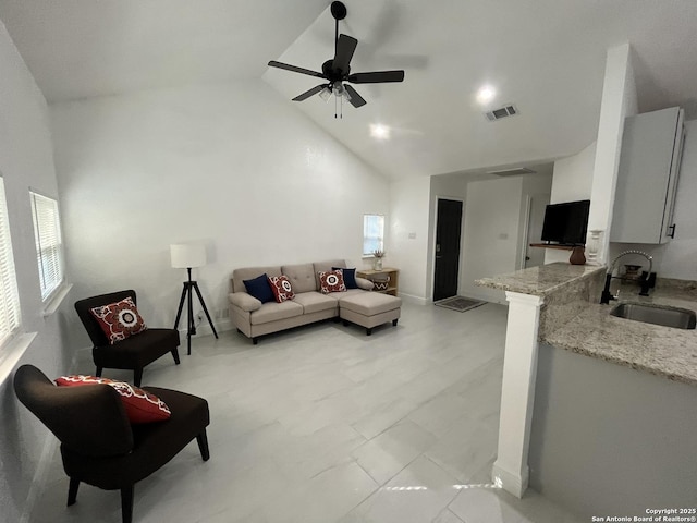 living room featuring ceiling fan, sink, and high vaulted ceiling