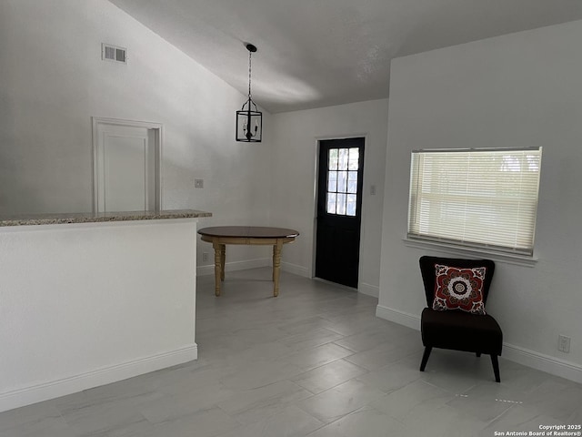 entryway featuring lofted ceiling and a chandelier